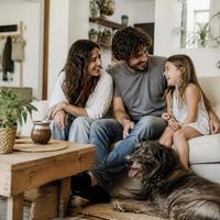 Familia en el living de su casa con su perro